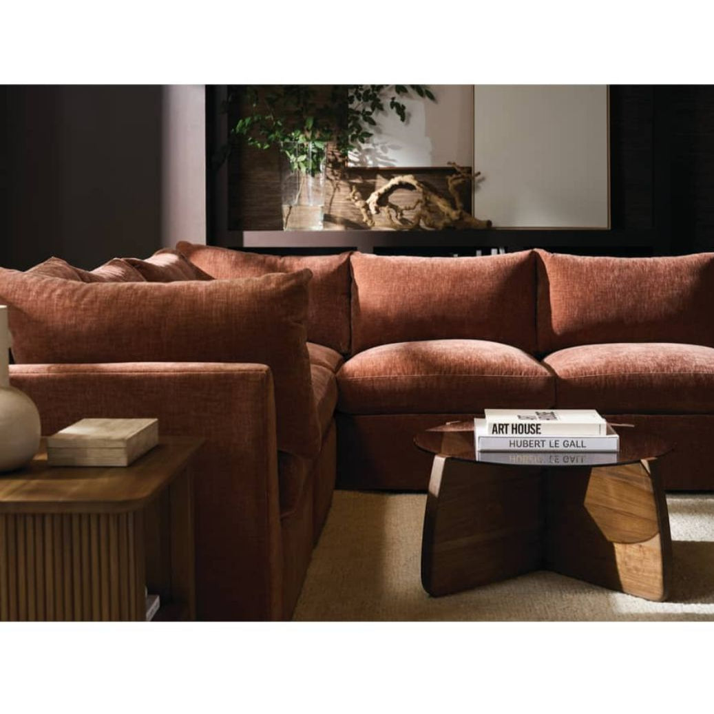 Brown sectional sofa in a living room setting with a coffee table and decorative items.