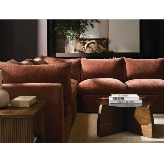 Brown sectional sofa in a living room setting with a coffee table and decorative items.